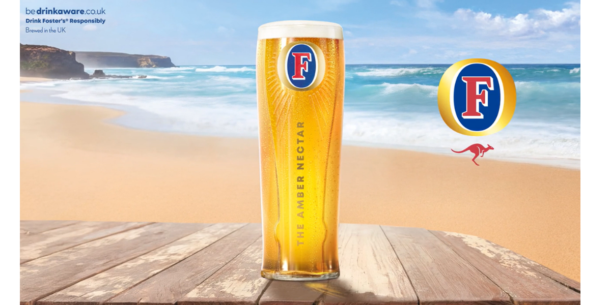 A pint of FOSTERS sat on a table with a sunny beach background. A pint of FOSTERS sat on a table with a sunny beach background.